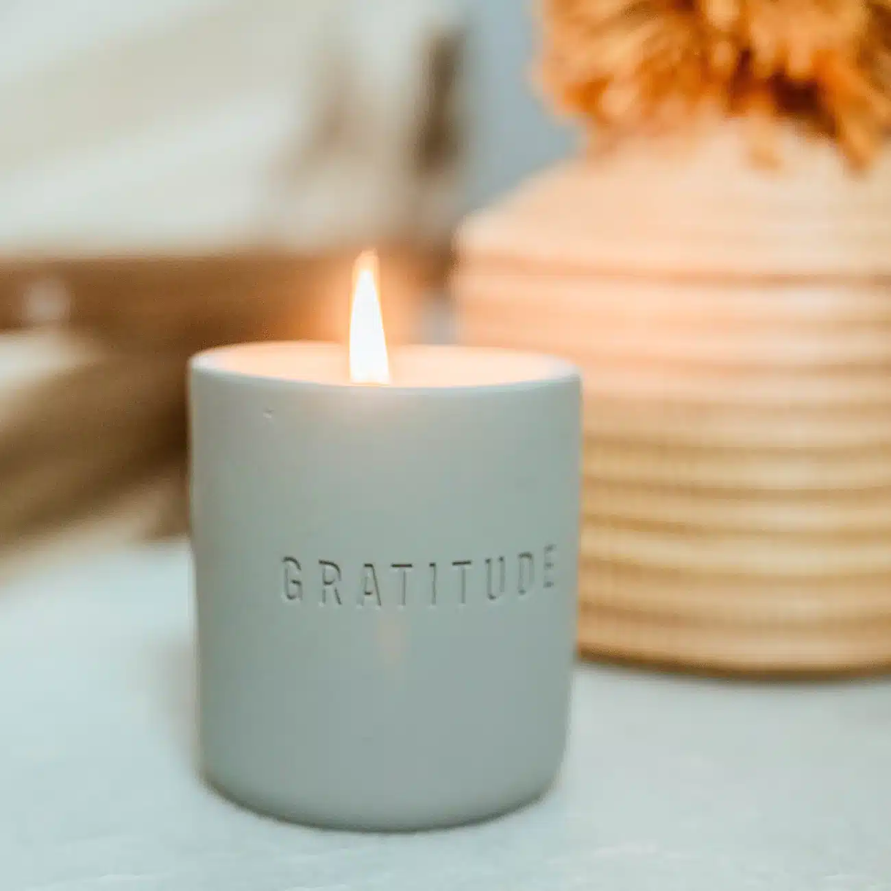 gratitude candle 2 Lit gratitude candle in front of a vase