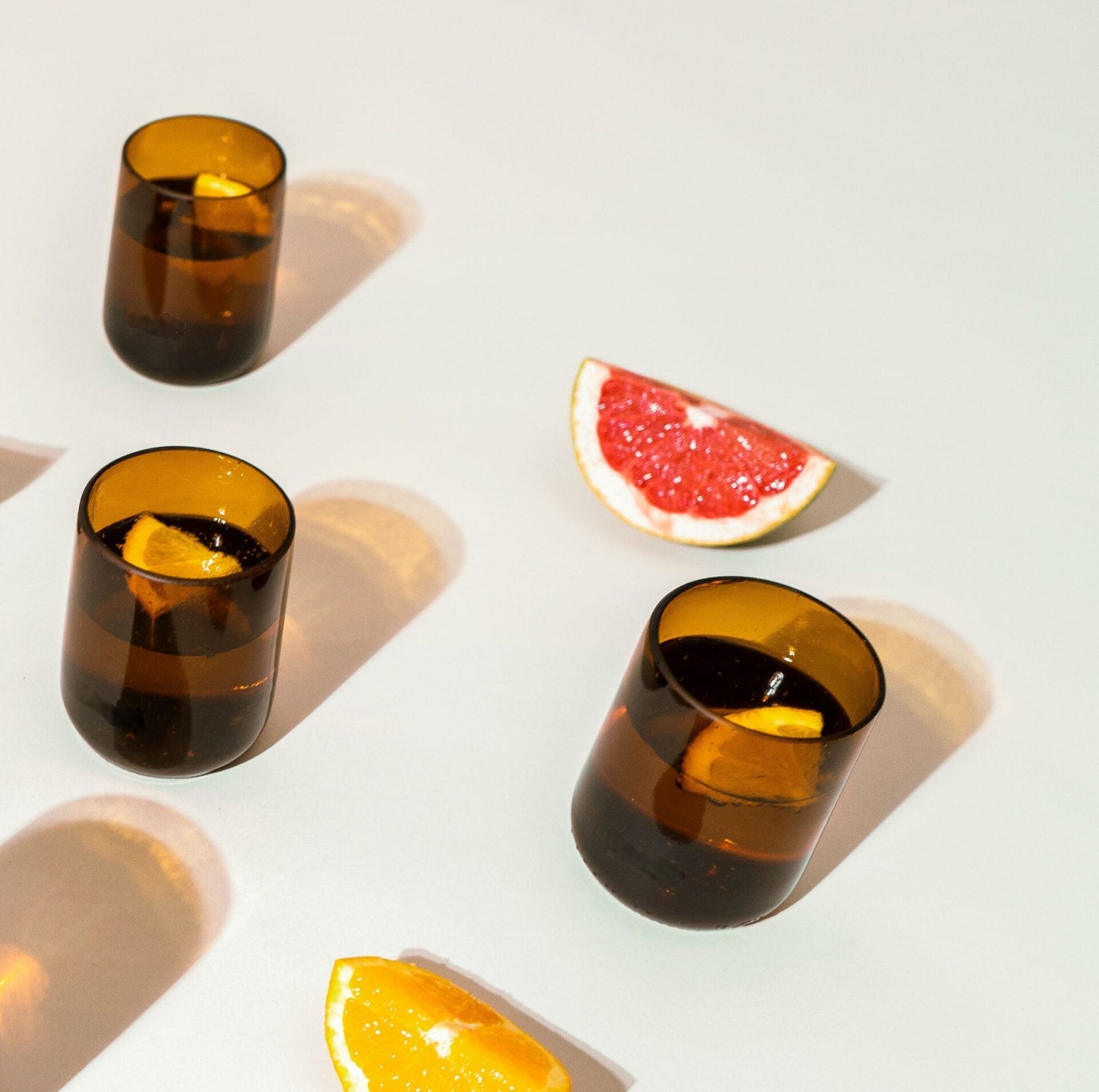 4 pack gronn amber glasses Amber glasses upcycled from Modelo beer bottles photographed with citrus fruit slices