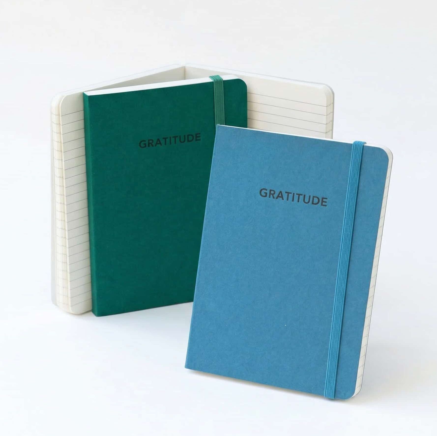 craft boat gratitude notebooks A blue and a green notebooks standing next to each other that have "Gratitude" debossed on the front cover
