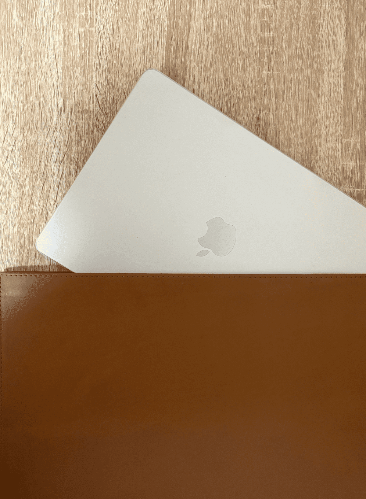 deux mains leather laptop sleeve in cognac a laptop peeks out of a cognac leather laptop sleeve - a great onboarding gift