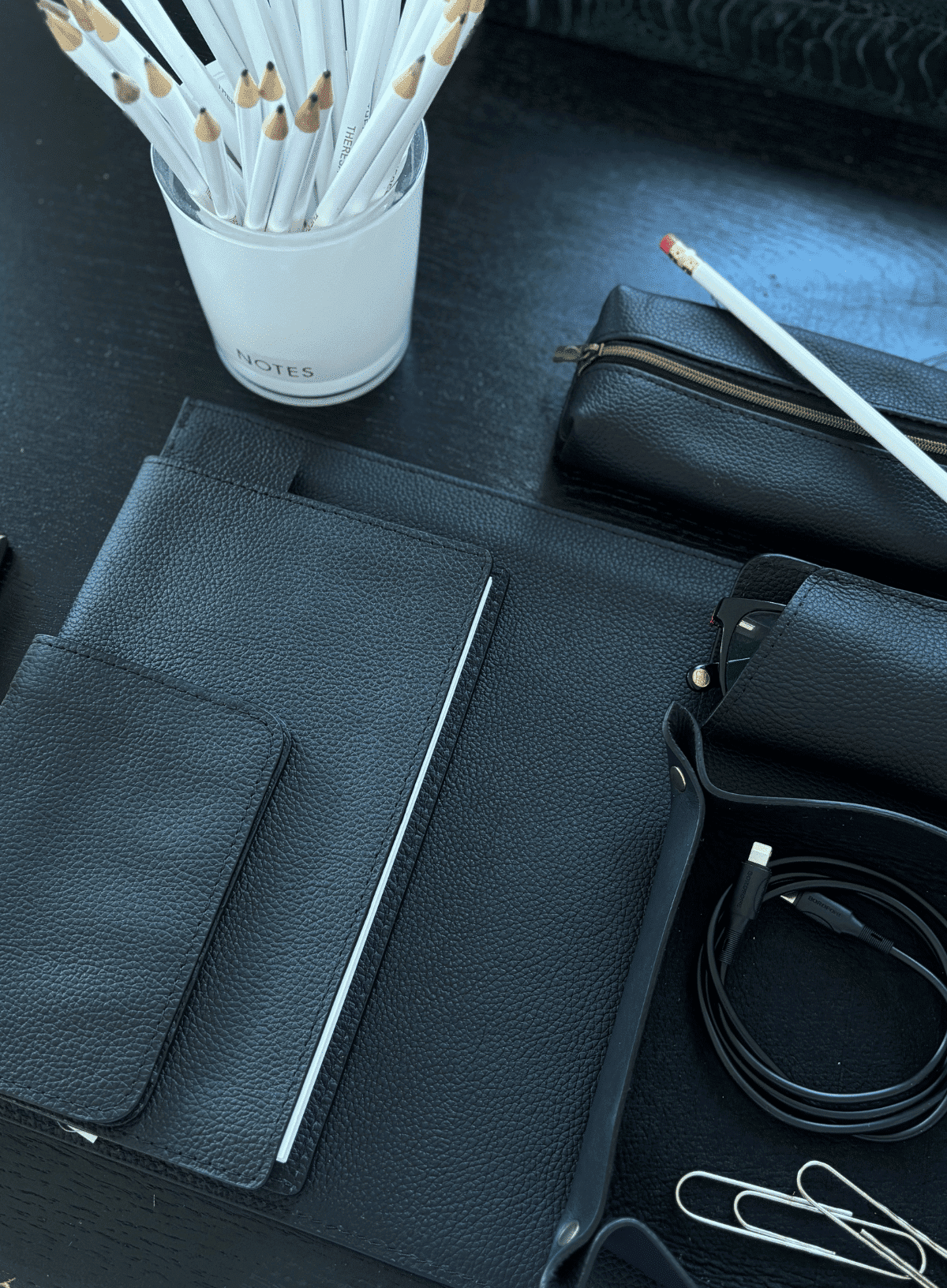 deux mains corporate gifts in black a selection of corporate gifts in black leather sit on a desk