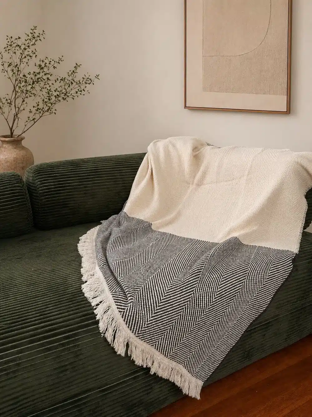 S&A American Made Slate blanket lifestyle a gray and white blanket lays across a velvet green couch
