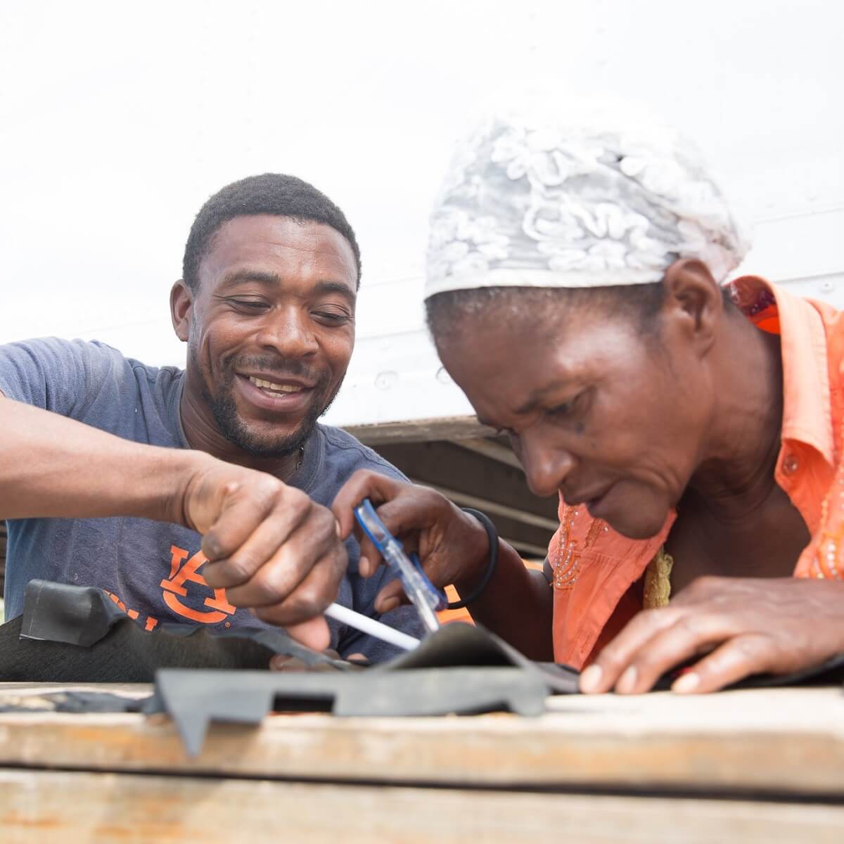 man helping woman cut rubber man helping woman cut rubber