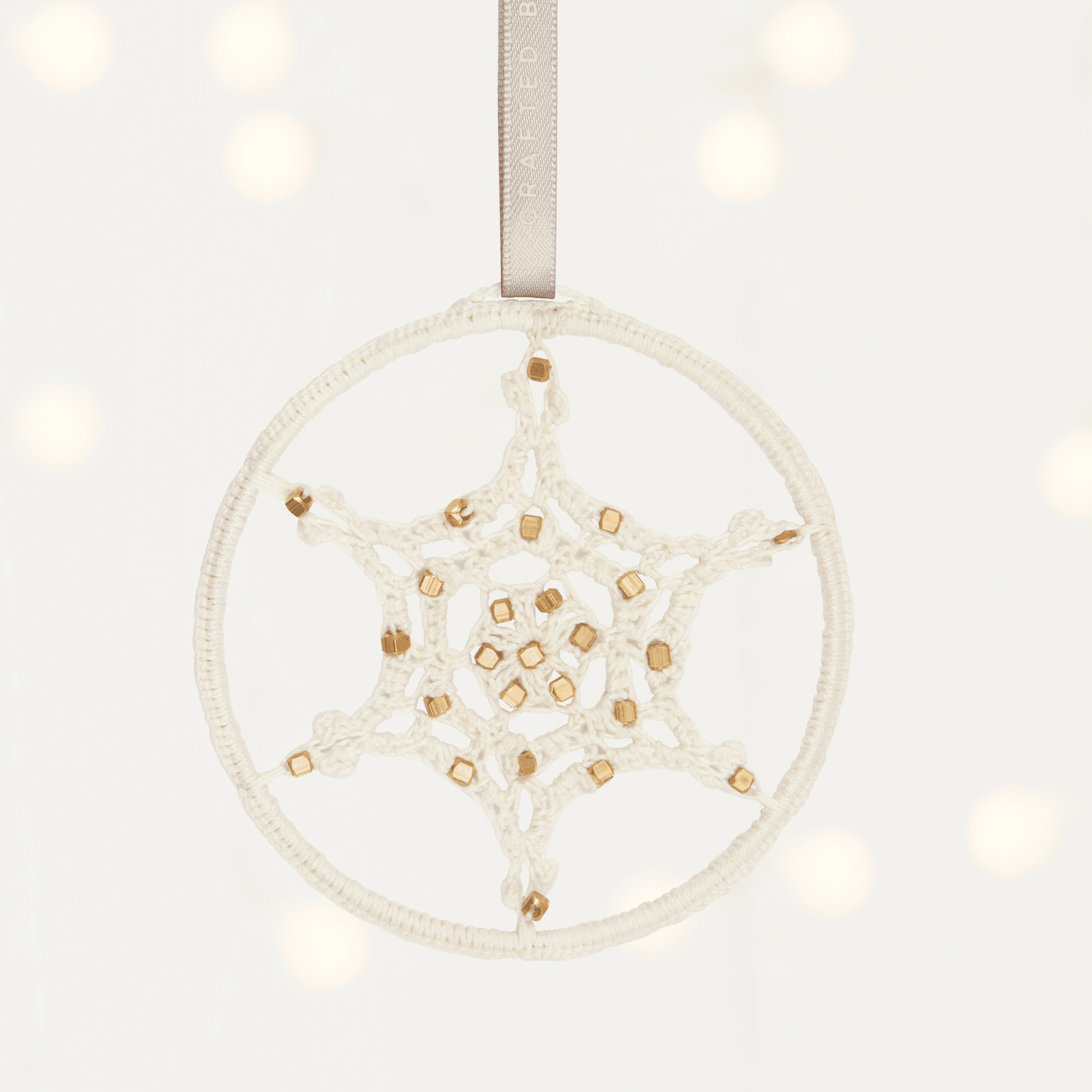 MADE51 Eternal Snowflake A round white and gold handmade ornament encircling a snowflake. Supports refugees and makes a unique client gift for the holidays