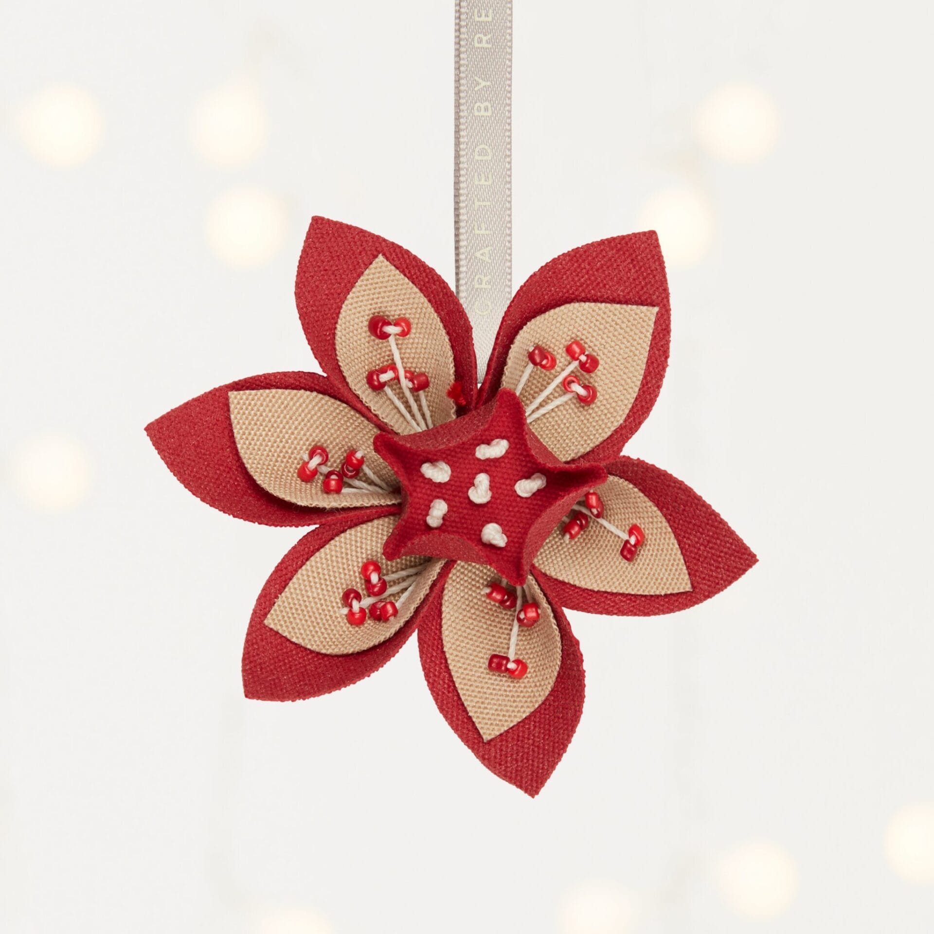 MADE51 Flower of Life ornament a handmade red and tan flower ornament that supports refugees. A thought holiday gift for clients