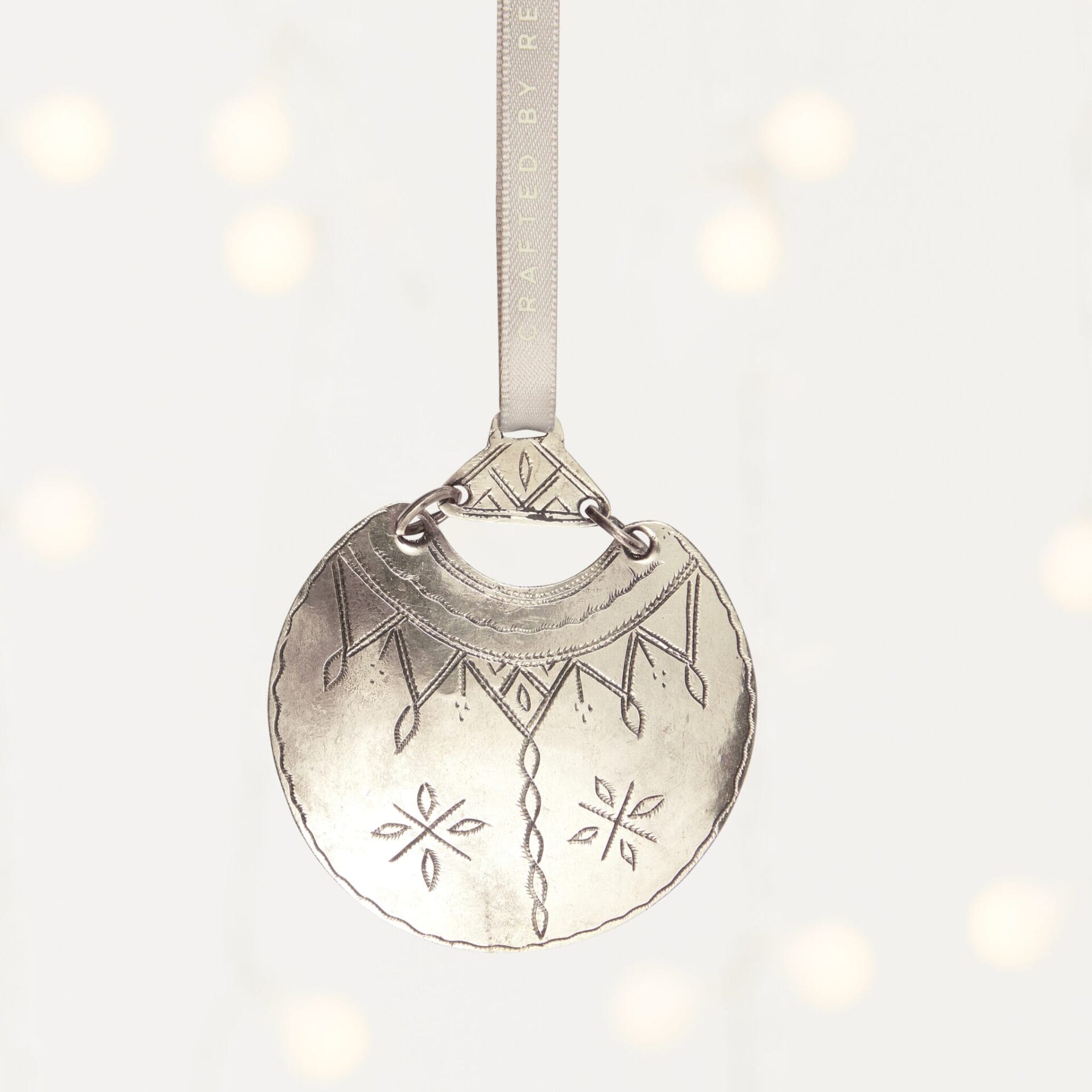 MADE51 Desert Moon a metallic, round ornament with intricate designs that supports refugees. A unique client holiday gift