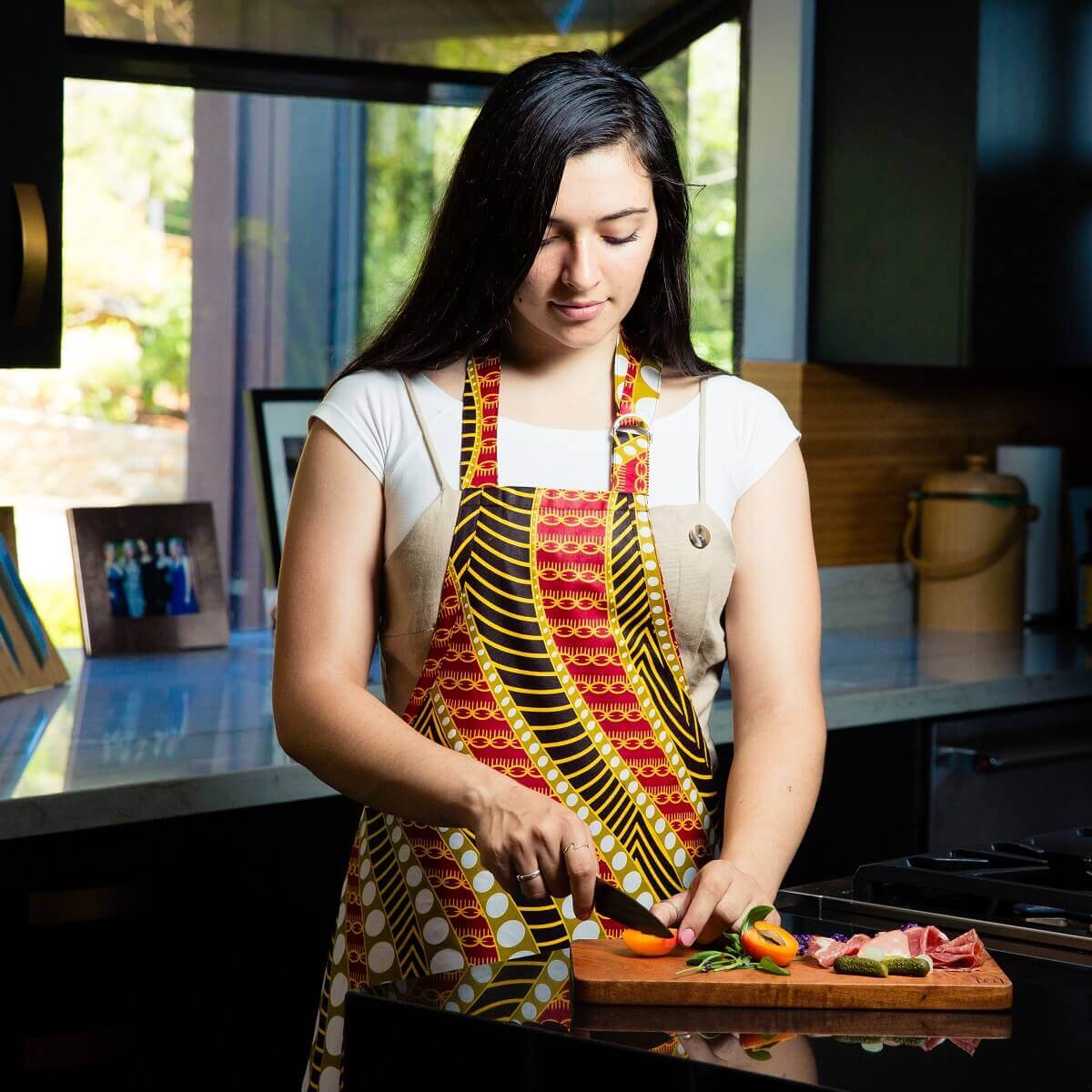 Model in apron at cutting board Model in apron at cutting board