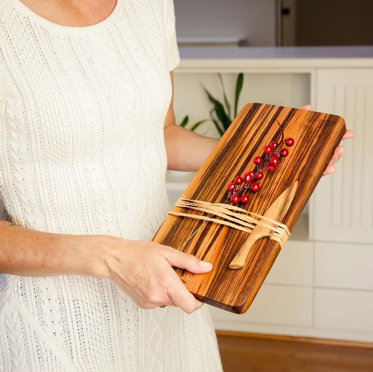 Woman holding cutting board with knife Woman holding cutting board with knife