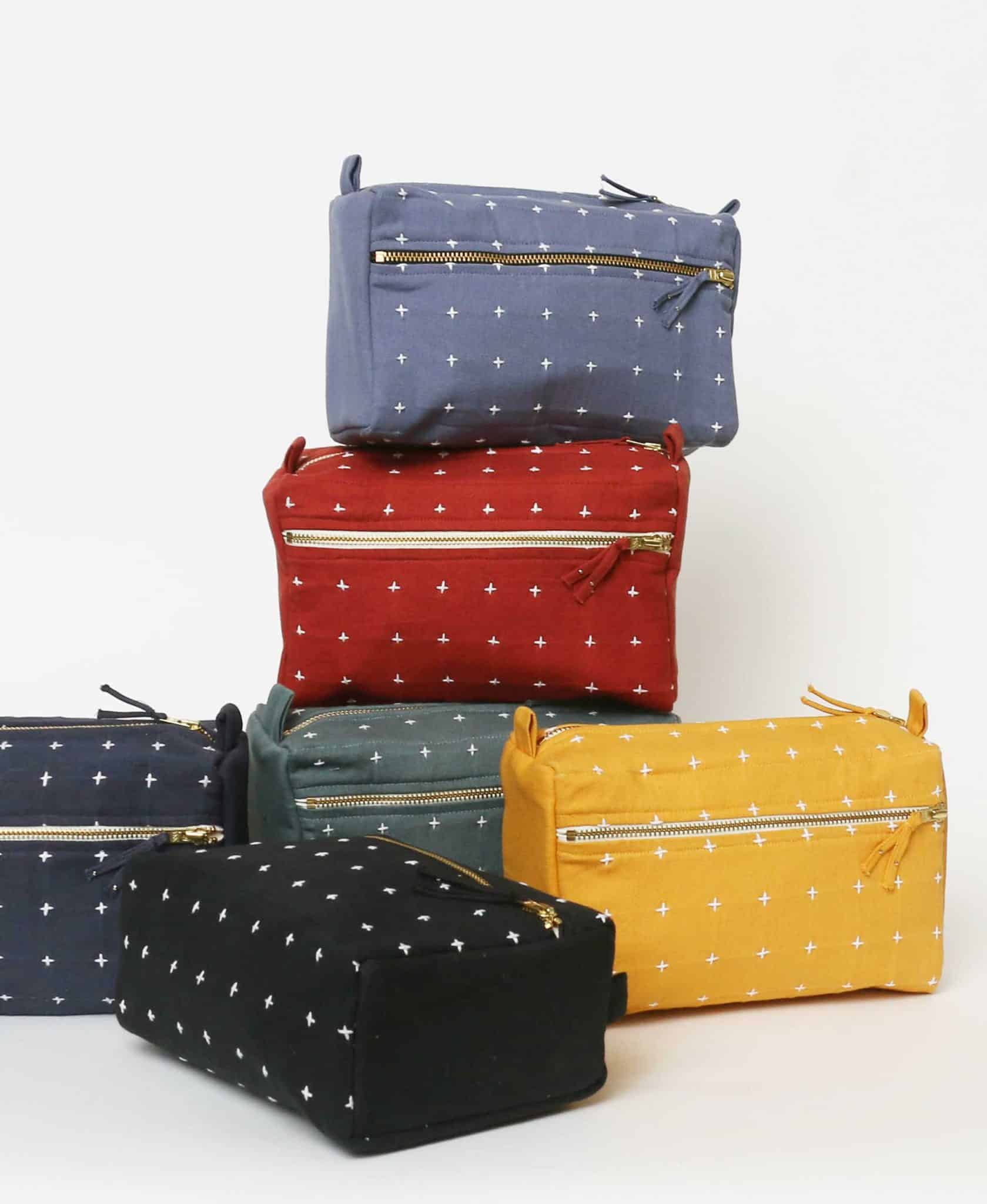 cross stitch toiletry bag mustard group Mustard group cross-stitch toiletry bags stacked vertically, showcasing assorted colors