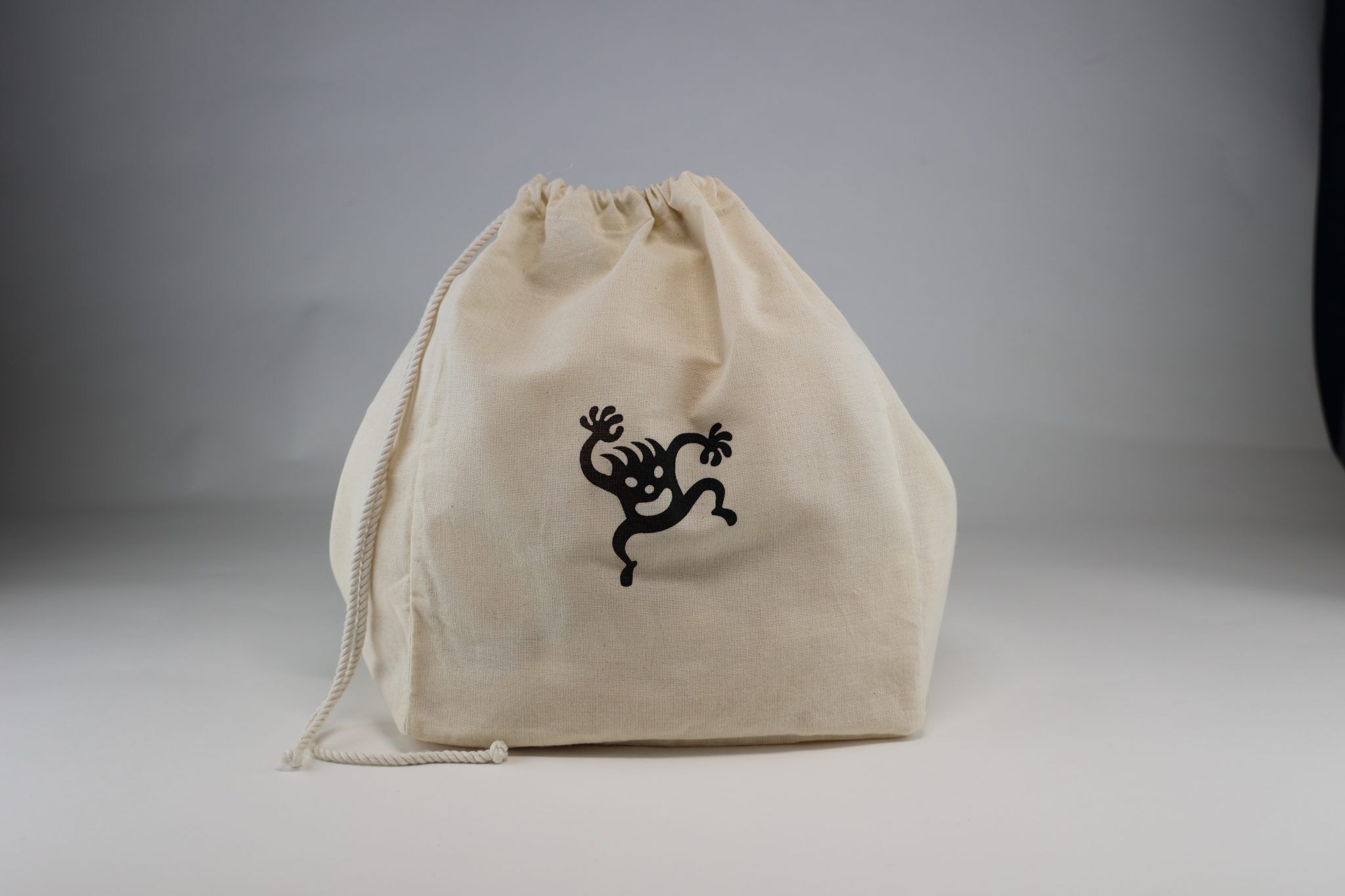 mi eelo drawstring gift bag mclarney A cream-colored drawstring muslin bag with a simple corporate logo sits against a white background