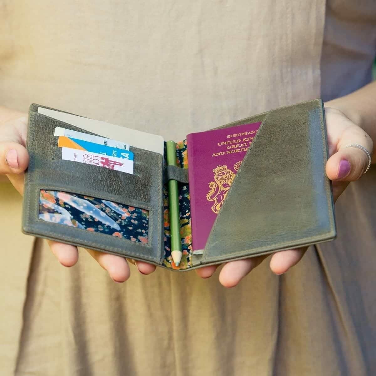 Woman holding open passport holder.jpg Open green leather passport holder held in hand, showing its interior