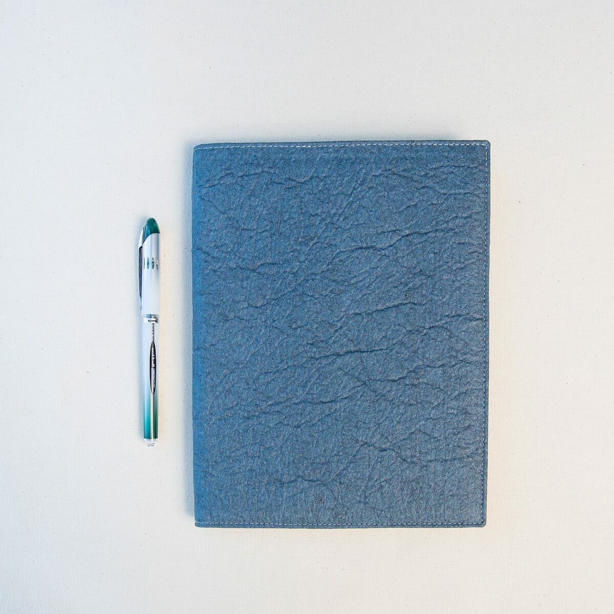 closed blue portfolio with pen closed blue portfolio with pen