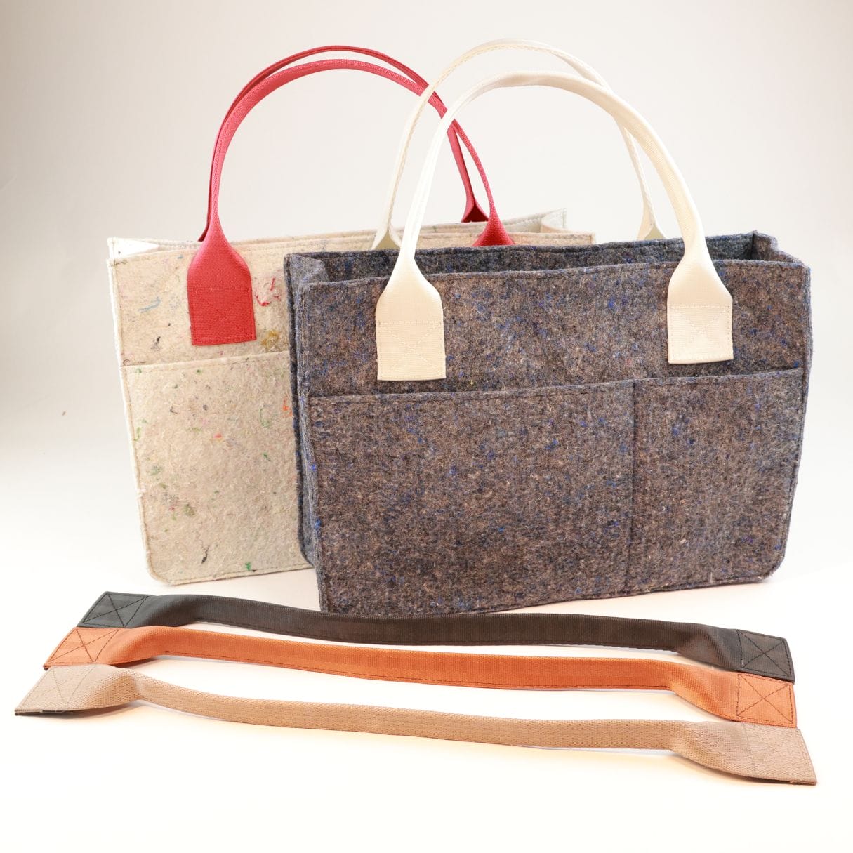 feelgood essentials tote coloroptions one white and one gray tote stood up next to a variety of handles showing different color options