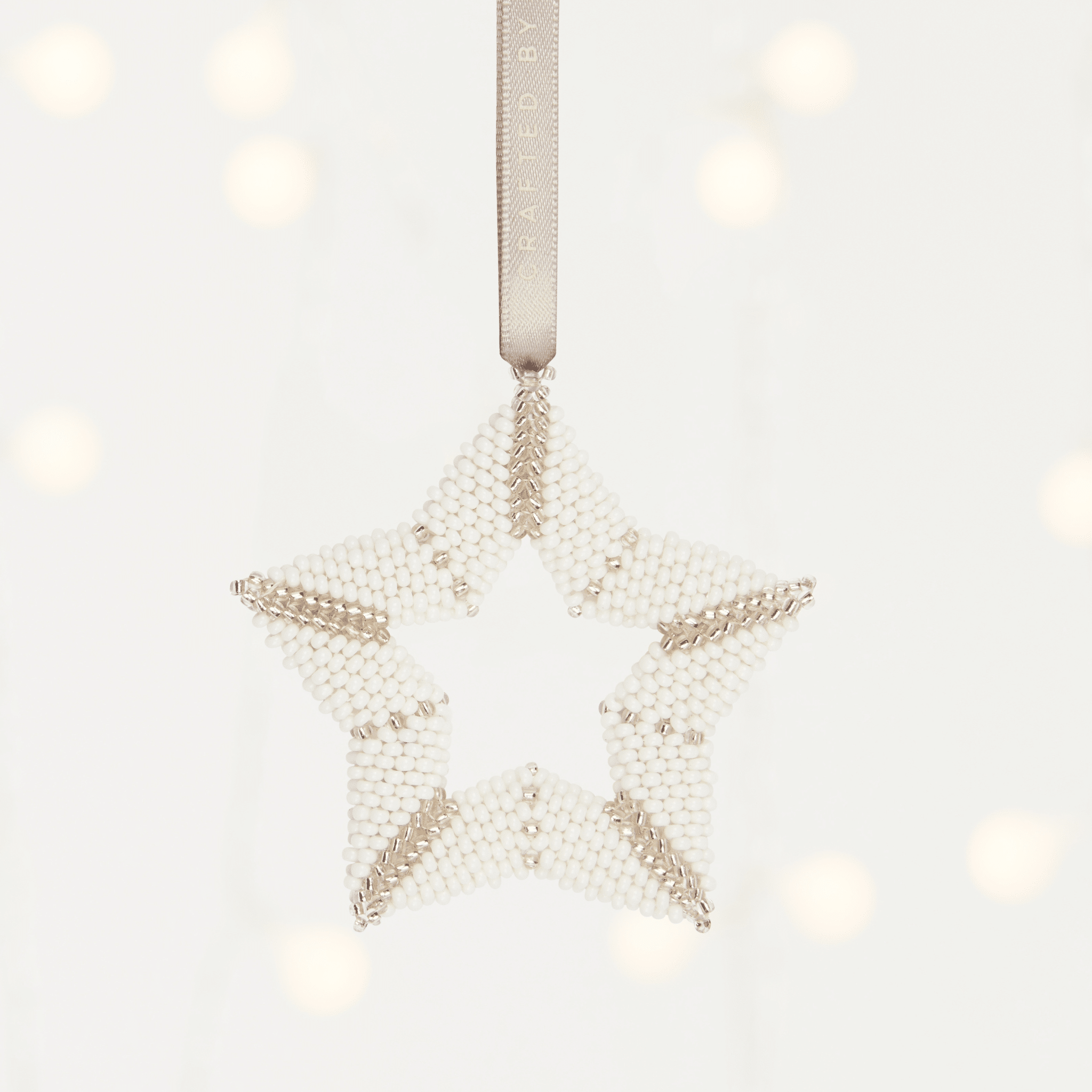 MADE51 Star of Unity a white and gold handmade star ornament that supports refugees. A great holiday gift for clients.