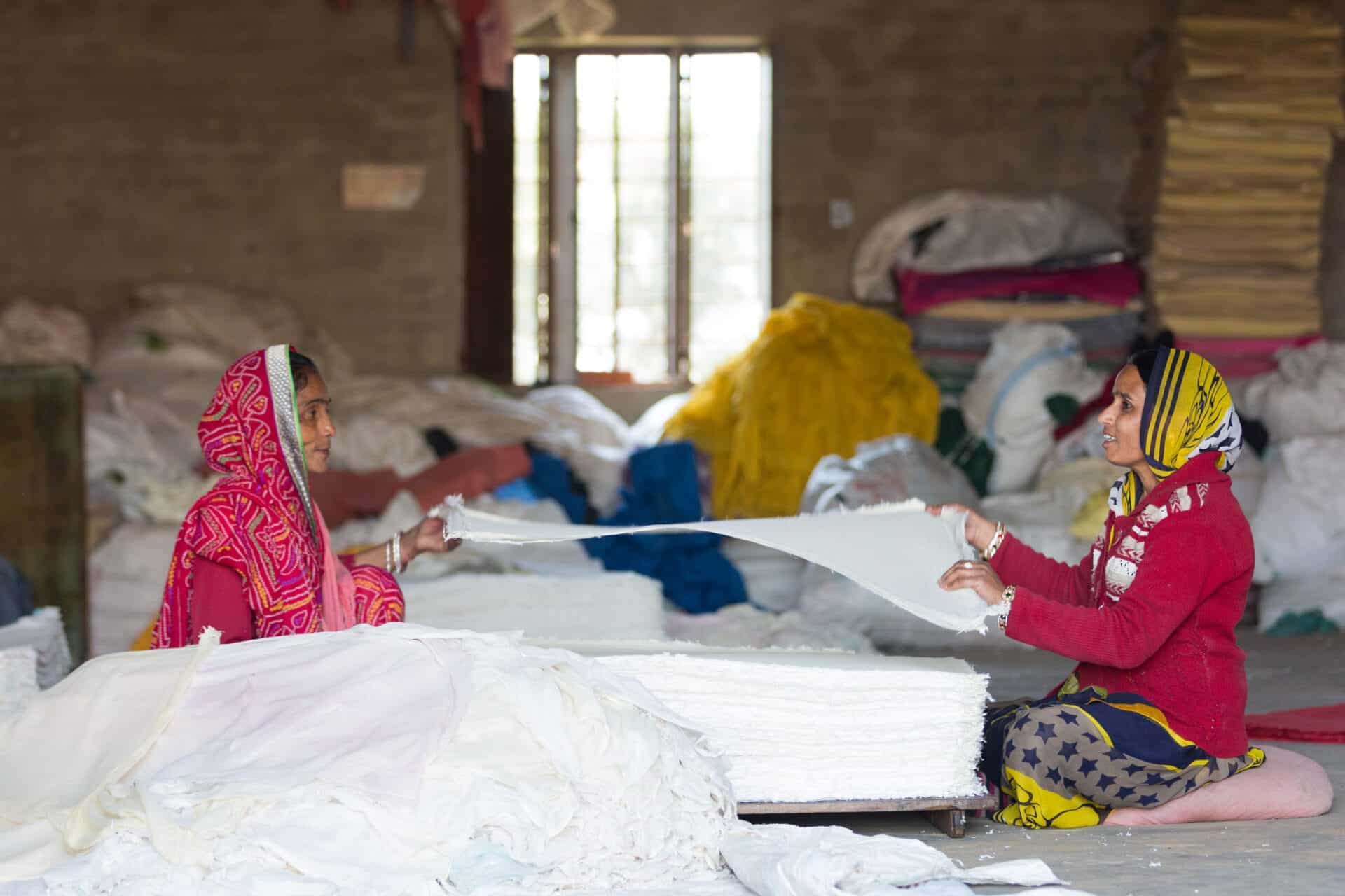 women working with paper from recycled textile waste craft boat handmade notebooks providing dignified work to women in India
