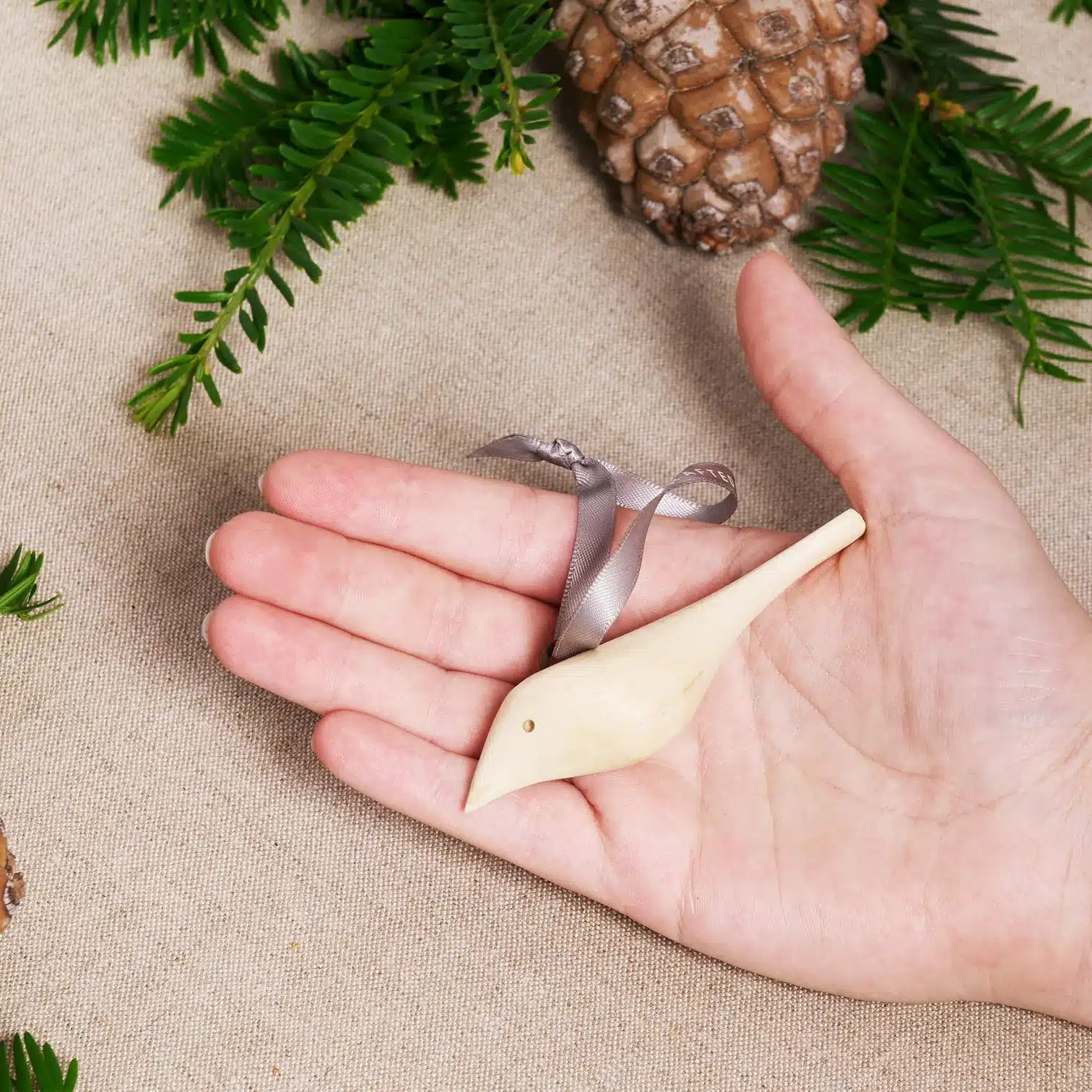 peaceful dove ornament MADE51 a small wooden dove ornament is held gently in a hand